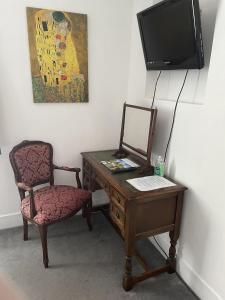 a desk with a chair and a television on a wall at The Lamb Inn in Marlborough
