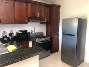 cocina con nevera de acero inoxidable y fogones en Apartamentos Kika en San Felipe de Puerto Plata