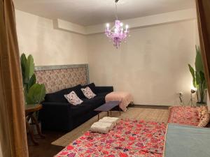 a living room with a black couch and a chandelier at Lovely cosy Art flat át city center in Budapest
