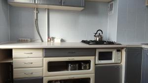 a kitchen with a stove and a microwave at Василя Стуса 10/77 City Rooms in Bila Tserkva