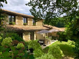 an external view of a house with an umbrella at La Libertie in Campsegret