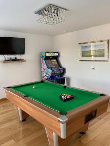 a room with a pool table and a video game at The Townhouse in St Andrews