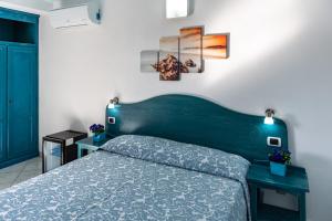 ein Schlafzimmer mit einem Bett und einem blauen Kopfteil in der Unterkunft Hotel Quasar in Cala Liberotto