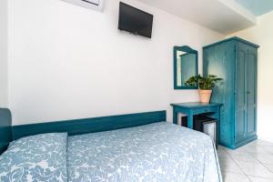 a bedroom with a blue wall and a blue bed at Hotel Quasar in Cala Liberotto