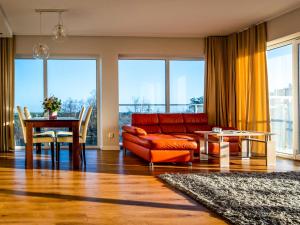a living room with a red couch and a table at Słoneczna 10a w Jarosławcu Apartamenty nad morzem in Jarosławiec