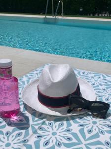 a hat and sunglasses sitting on a table by a pool at Marbella GOLF & SEA LODGE - HEATED POOL 28 degrees 365 days in Estepona