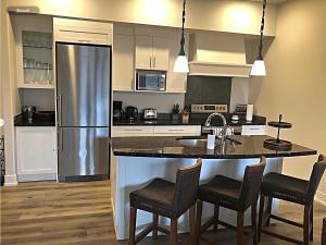 a kitchen with a counter and a refrigerator at Spectacular Penthouse With Amazing Views, Indoor Pool and Hot tub in Canmore
