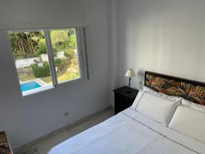 biała sypialnia z łóżkiem i oknem w obiekcie Residencial las Flores Marbella w Marbelli +24 zdjęcia