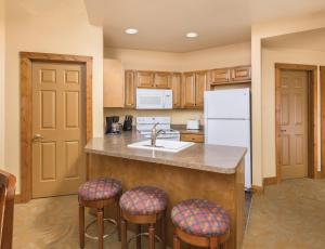 a kitchen with a sink and two bar stools at WorldMark Galena in Galena