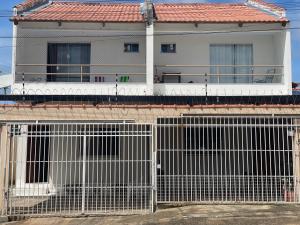 a house with white fences in front of it at Flat hotel Victoram in Rio Branco
