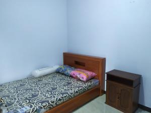 a bedroom with a bed and a night stand at Homestay Syariah Mami Borobudur in Borobudur