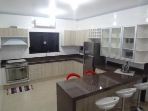 een grote keuken met een aanrecht en krukken. bij Hotel Fazenda Flamarion in Lagoa Santa