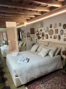 a large white bed in a bedroom with pictures on the wall at Penelope's House in Rome