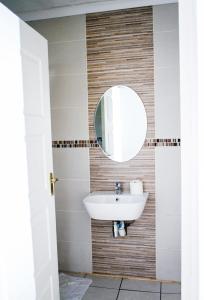 a bathroom with a sink and a mirror at Happy Hen Guest Lodge in Bizana