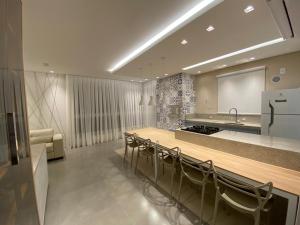a large kitchen with a long table and chairs at Meia Praia Quadra Mar in Itapema +17 photos