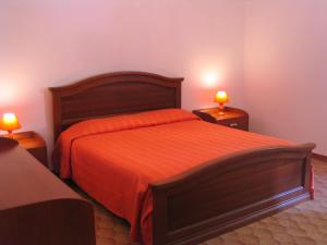 アルゲーロにあるBarbagia Apartmentのベッドルーム1室(オレンジのシーツとランプ2つ付)