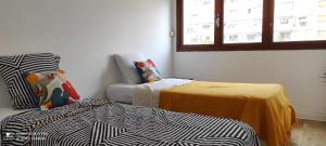 Cette chambre comprend deux lits, un canapé et une fenêtre. dans l'établissement Appartement vacances Marseille, à Marseille