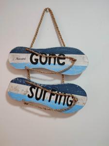 a pair of slippers with some surfing written on them at Big Wave House in Nazaré
