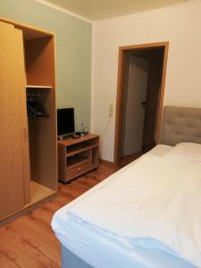 a bedroom with a bed and a desk with a computer at Der Prinsenhof in Porta Westfalica