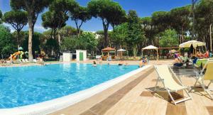 a large swimming pool with people in the water at ISOLA VERDE Camping Village in Nettuno