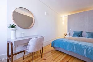 a bedroom with a bed with a desk and a mirror at National Theatre Flat in Porto