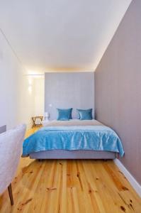 a bedroom with a large bed with blue sheets at National Theatre Flat in Porto