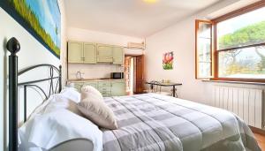 biała sypialnia z łóżkiem i kuchnią w obiekcie Agriturismo Barbadoro w mieście San Vincenzo