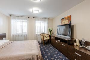 a hotel room with a bed and a flat screen tv at Incognito Boutique Hotel in Kyiv