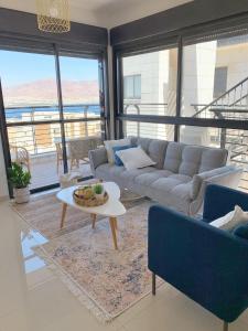 a living room with a couch and a table at Sea view penthouse Private rooftop jacuzzi in Eilat