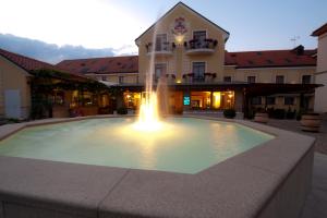 a large pool in front of a building with a fountain at Hotel Princess in Lednice