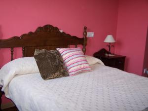 a bedroom with a bed with two pillows on it at Casa El Trabeseo in San Martín de Luiña