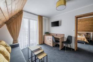 een hotelkamer met een bed, een bureau en stoelen bij Janosówka in Czarna Góra
