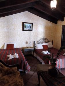 a bedroom with two beds and a couch in it at Casa Catalina in Antigua Guatemala