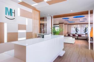 a lobby with a white counter and a couch at Mònica Hotel in Cambrils