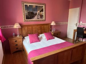 a bedroom with a large bed with pink sheets at Logis Hôtel L'Adourable Auberge in Soublecause