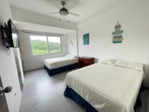 1 dormitorio con 2 camas y ventana en Departamento vista al mar 2D, en Tonsupa