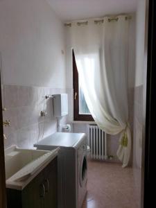 a bathroom with a washing machine next to a tub at Casa Degli Ulivi in Lazise +18 photos