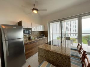 une cuisine avec un réfrigérateur en acier inoxydable et un comptoir dans l'établissement Departamento vista al mar 2D, à Tonsupa 5 autres photos