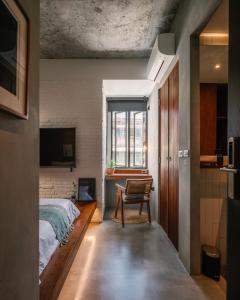 バンコクにあるTamniのベッドルーム1室(ベッド1台、椅子、窓付)