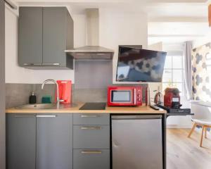 uma cozinha com um micro-ondas vermelho no balcão em Appartement T2- Le bon accueil / WIFI / PARKING em Angoulême