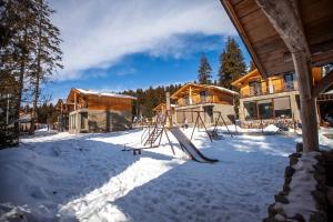 a playground in the snow in front of a house at Green Hills in Bakuriani