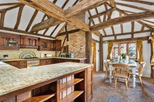 een keuken met houten plafonds en een tafel met stoelen bij Finest Retreats - Sandhill Cottage with hot tub in Turners Hill