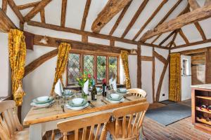 comedor con mesa de madera y sillas en Finest Retreats - Sandhill Cottage with hot tub, en Turners Hill