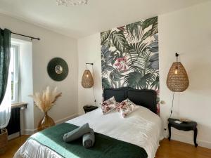 a bedroom with a bed with a tropical wallpaper at La Naomath - Maison d'hôtes, Hébergement insolite & Gîte in Bayeux