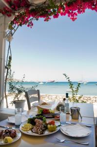 un tavolo con cibo e vista sulla spiaggia di Camping Koula a Paroikia
