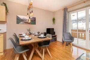 a kitchen and dining room with a table and chairs at Alpinresort Kaprun 4 in Kaprun