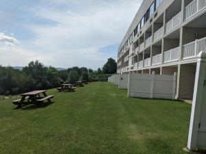 a row of picnic tables on the side of a building at Cedar Lodge Condo with Lake Winnipesaukee Views; close to Weirs Beach!! in Laconia