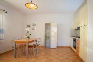 a kitchen and dining room with a table and chairs at Ville del Mar in San Teodoro