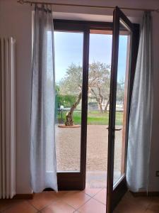 a sliding glass door with a view of a yard at Casa Degli Ulivi in Lazise