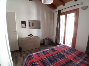 un dormitorio con una cama y una ventana en La casa del Ciodo, en Colico